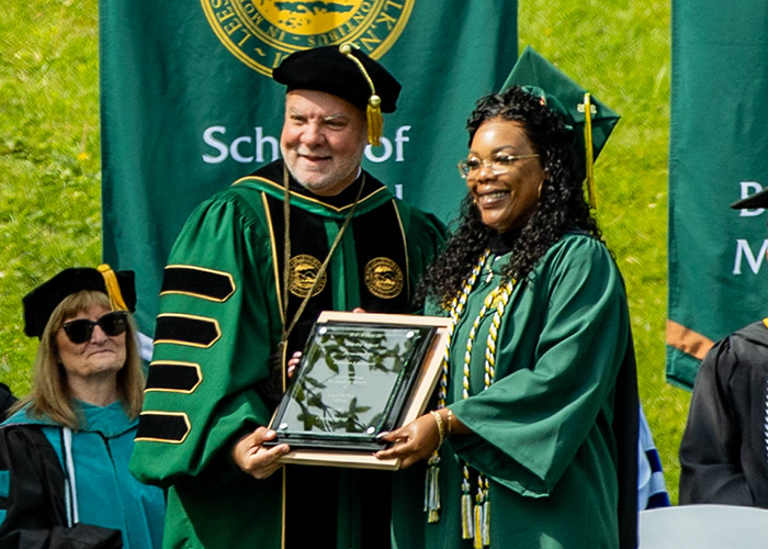Lakisha Lipscomb stands with President Lee King and holds her Fidelity Award plaque.