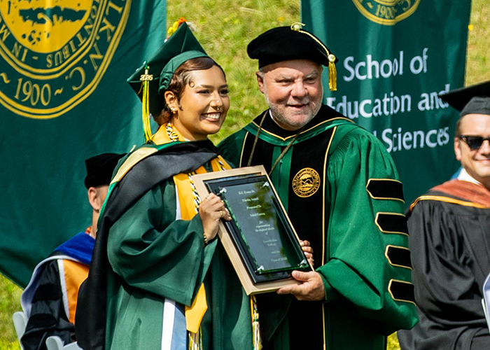 Soleil Correa stands with President Lee King and holds her Fidelity Award plaque.