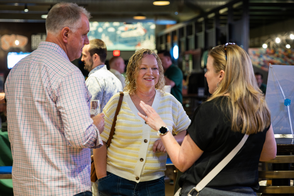 Lees-McRae alumni and friends have a conversation at an indoor Bobcat gathering.