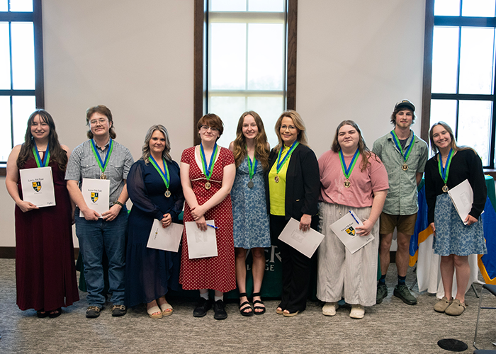 A group of students, each wearing a blue and green medal.
