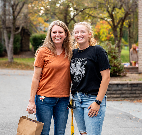 Two people smile together outdoors during a Lees-McRae Homecoming event.