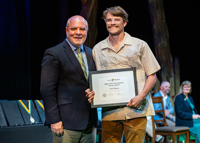 Peter Wallace smiles with President King while holding his award.