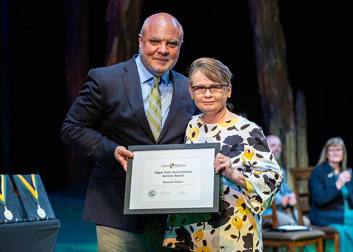 Ramona Hayes smiles with President King while holding her award.